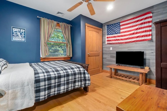 bedroom featuring ceiling fan, wood finished floors, and visible vents
