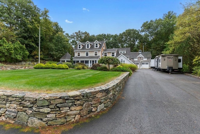 view of front of home featuring an attached garage, driveway, and a front yard