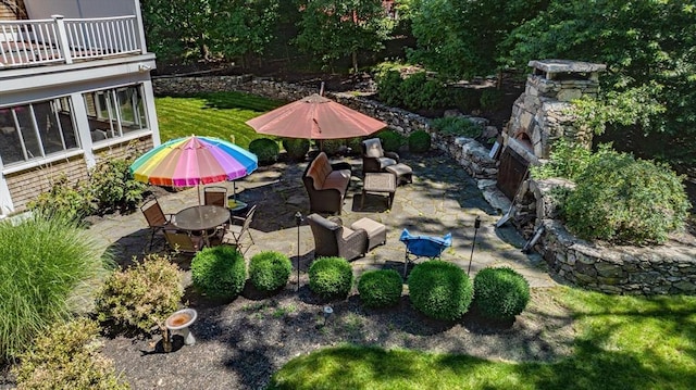 view of yard featuring outdoor dining area, a balcony, and a patio area