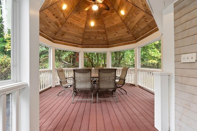 sunroom / solarium featuring ceiling fan, a wooden deck, outdoor dining area, hardwood / wood-style floors, and wooden ceiling