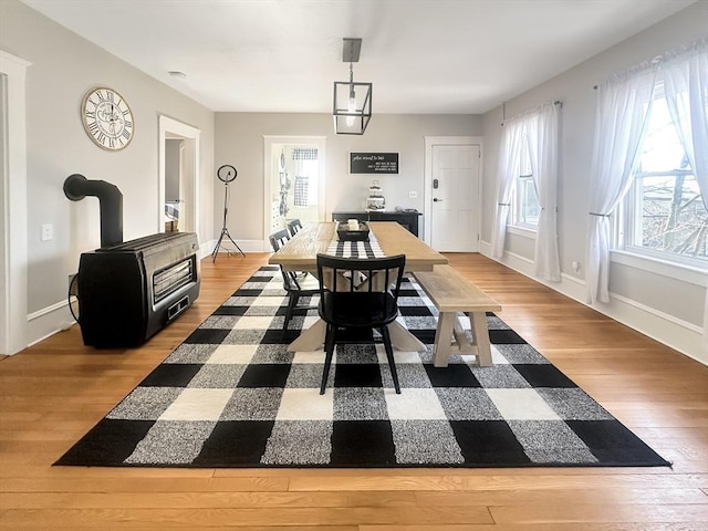 dining space featuring a wood stove and light hardwood / wood-style flooring