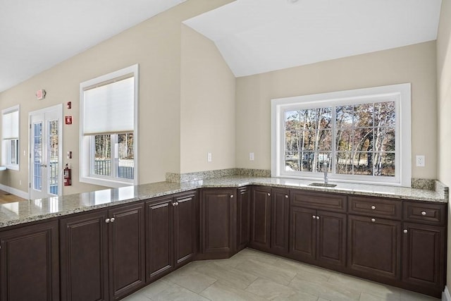 25 Salisbury Hill Blvd Unit 62, Worcester, MA 01609 - kitchen with a sink, dark brown cabinetry, light stone countertops, and a peninsula