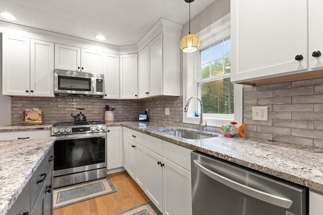 187 Run Brook Cir, Taunton, MA 02780 - kitchen featuring stainless steel appliances, light wood-type flooring, white cabinets, pendant lighting, and backsplash