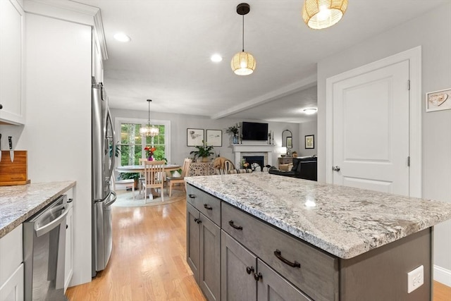 187 Run Brook Cir, Taunton, MA 02780 - kitchen with stainless steel appliances, light wood-style floors, white cabinets, a kitchen island, and hanging light fixtures