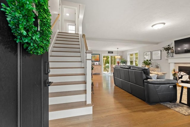 187 Run Brook Cir, Taunton, MA 02780 - living area featuring stairs, wood finished floors, a fireplace, and a chandelier