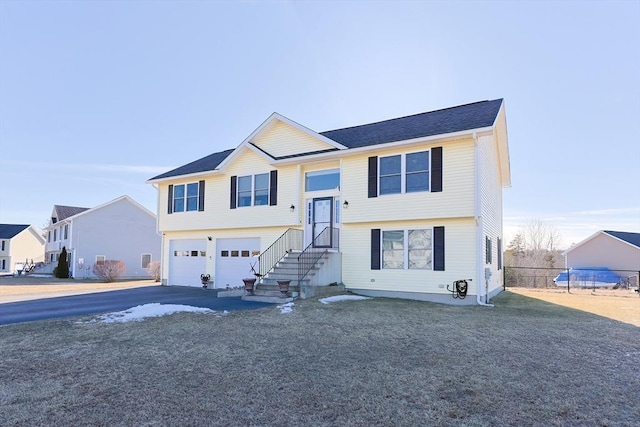 bi-level home with a garage and a front lawn