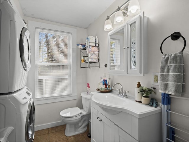 73 Laurel St, Leominster, MA 01453 - bathroom with tile patterned flooring, stacked washer and dryer, toilet, and vanity