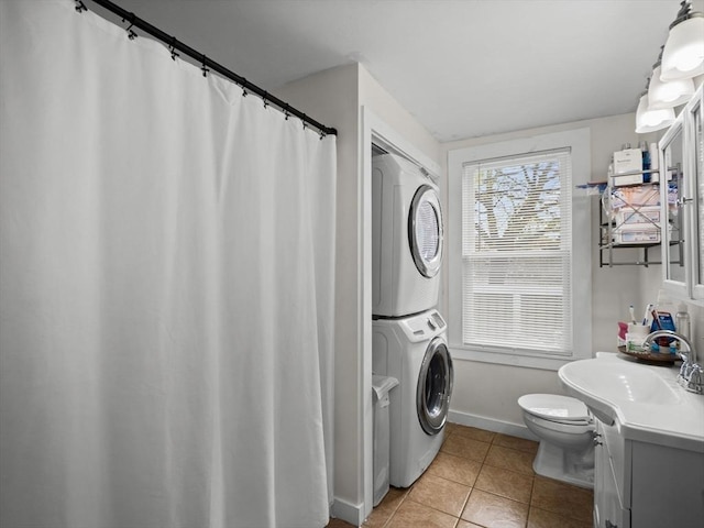 73 Laurel St, Leominster, MA 01453 - full bathroom featuring tile patterned flooring, vanity, toilet, stacked washing maching and dryer, and baseboards