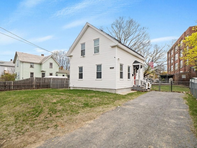 73 Laurel St, Leominster, MA 01453 - rear view of house featuring a yard, fence, and aphalt driveway