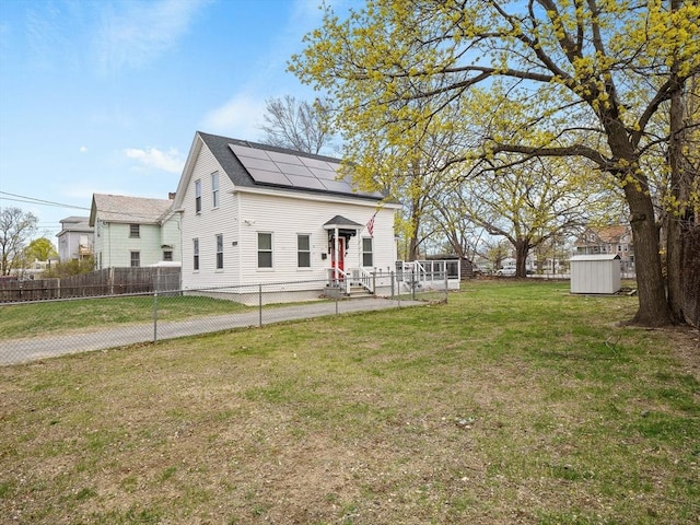 73 Laurel St, Leominster, MA 01453 - view of front of home with solar panels, an outbuilding, fence private yard, a shed, and a front lawn