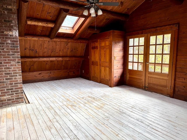 interior space with ceiling fan, a skylight, and french doors