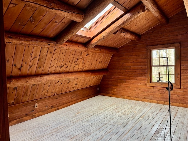 additional living space featuring wood ceiling, wooden walls, lofted ceiling with skylight, and light hardwood / wood-style flooring