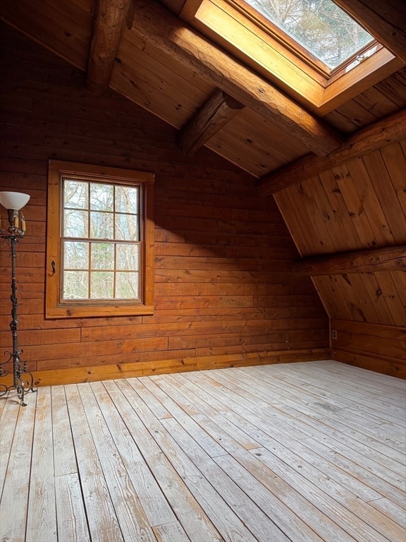 bonus room with a healthy amount of sunlight, wood ceiling, wooden walls, and light hardwood / wood-style flooring