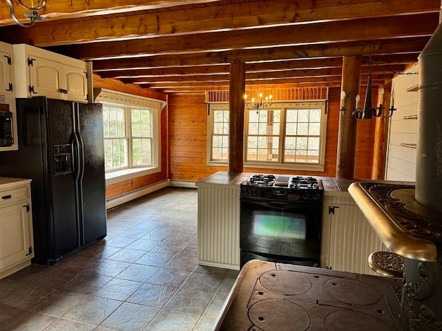 kitchen with white cabinetry, wooden walls, a baseboard heating unit, tile counters, and black appliances