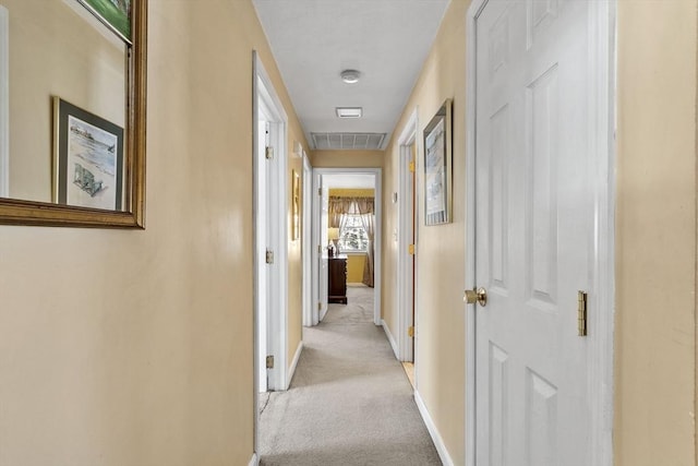 hallway featuring light colored carpet