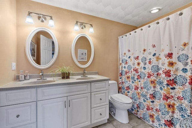 bathroom with tile patterned flooring, vanity, and toilet