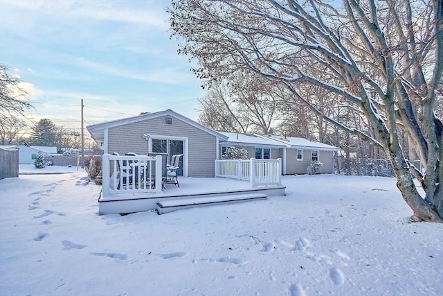 snow covered property featuring a wooden deck