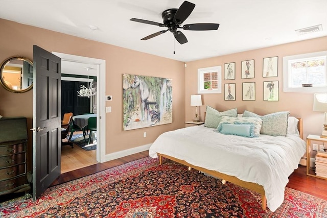 bedroom with wood finished floors, baseboards, and a ceiling fan