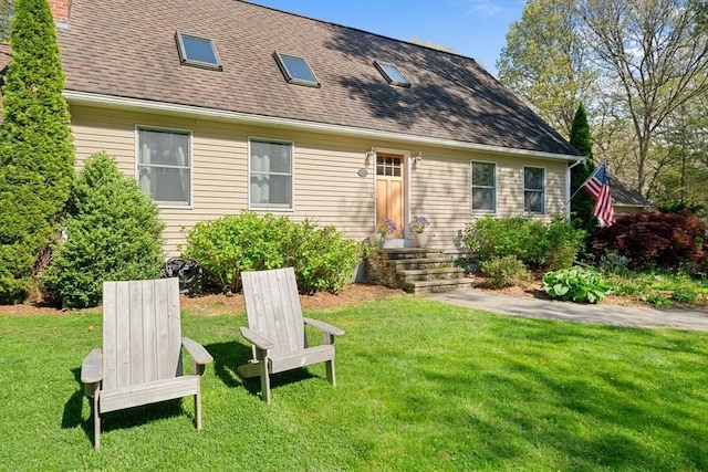 back of property featuring a lawn, a chimney, and a shingled roof
