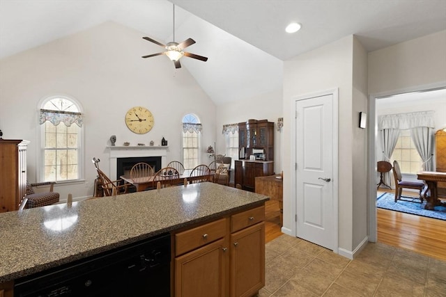 kitchen featuring dishwasher, high vaulted ceiling, ceiling fan, dark stone countertops, and light hardwood / wood-style floors