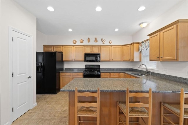 kitchen with a breakfast bar, black appliances, sink, light tile patterned floors, and kitchen peninsula