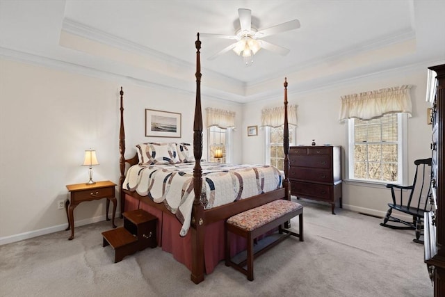 carpeted bedroom with a tray ceiling, ceiling fan, and ornamental molding