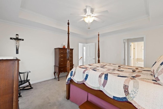 bedroom featuring ensuite bath, ornamental molding, light colored carpet, a raised ceiling, and ceiling fan