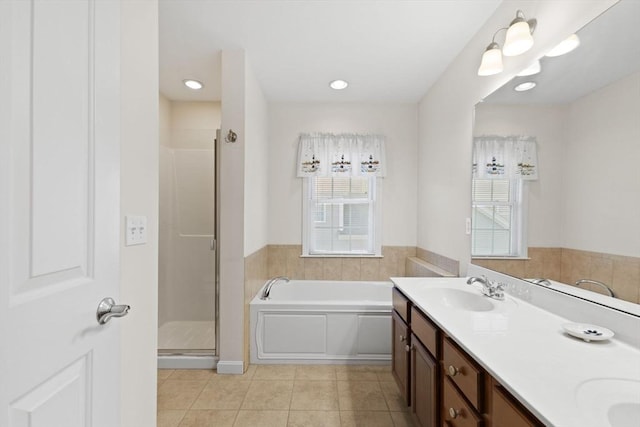 bathroom featuring plus walk in shower, tile patterned flooring, and vanity