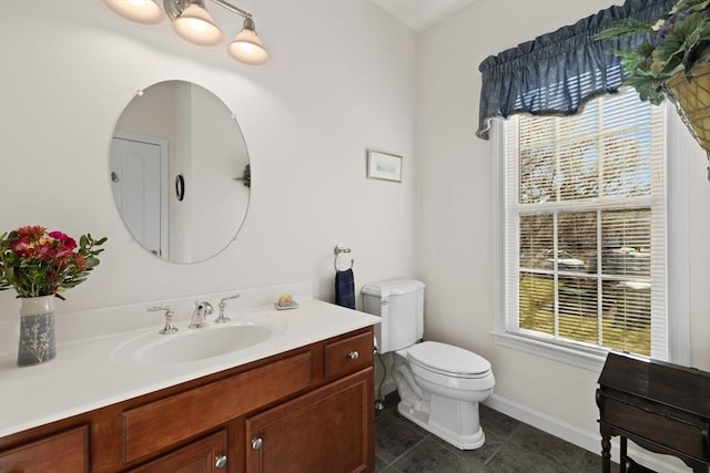 bathroom featuring tile patterned floors, a wealth of natural light, vanity, and toilet