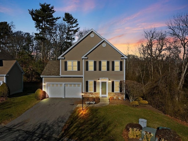 view of front facade featuring a garage and a lawn