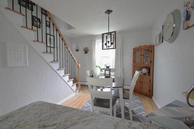 11 Dallas St, Worcester, MA 01604 - dining space featuring wood finished floors, stairway, a chandelier, baseboards, and a baseboard heating unit