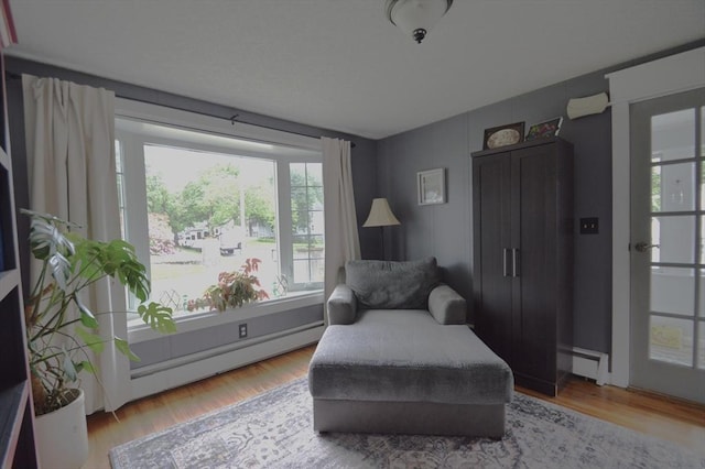 11 Dallas St, Worcester, MA 01604 - living area featuring a baseboard radiator, plenty of natural light, and wood finished floors