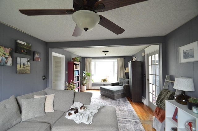 11 Dallas St, Worcester, MA 01604 - living room with light wood-type flooring, a ceiling fan, a textured ceiling, and a baseboard radiator