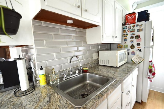 11 Dallas St, Worcester, MA 01604 - kitchen featuring white microwave, a sink, tasteful backsplash, and white cabinetry