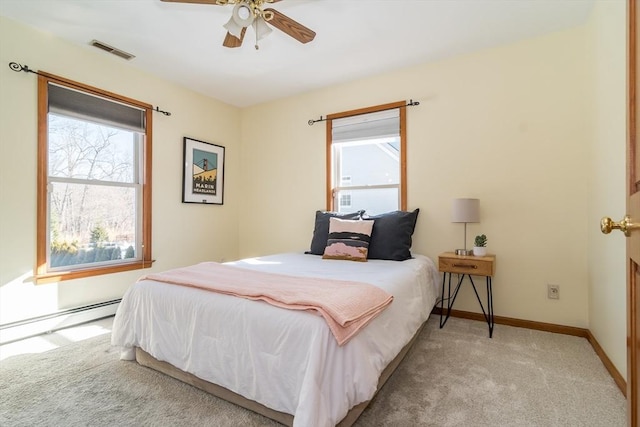 carpeted bedroom featuring multiple windows, a baseboard heating unit, and ceiling fan