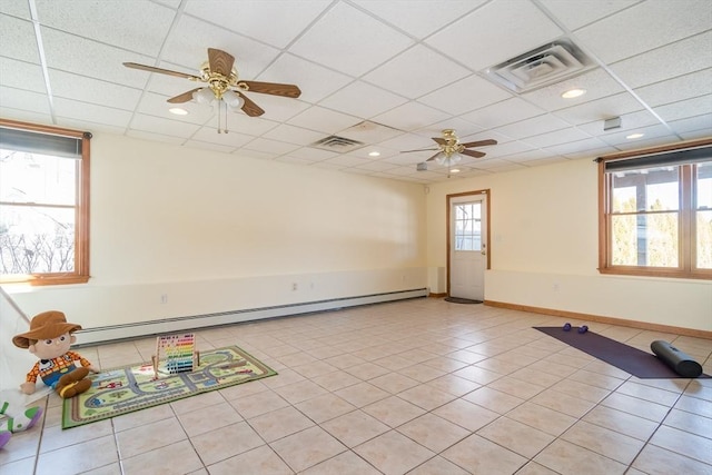 tiled spare room with ceiling fan, a paneled ceiling, and baseboard heating