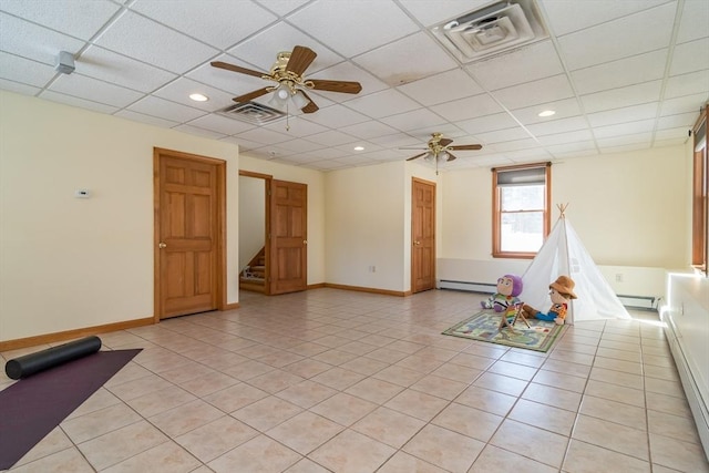 recreation room featuring light tile patterned flooring, a paneled ceiling, ceiling fan, and a baseboard heating unit