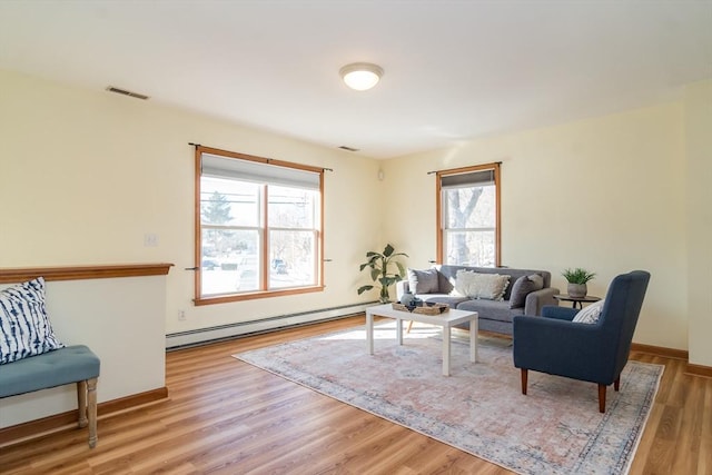 living room featuring light wood-type flooring and baseboard heating