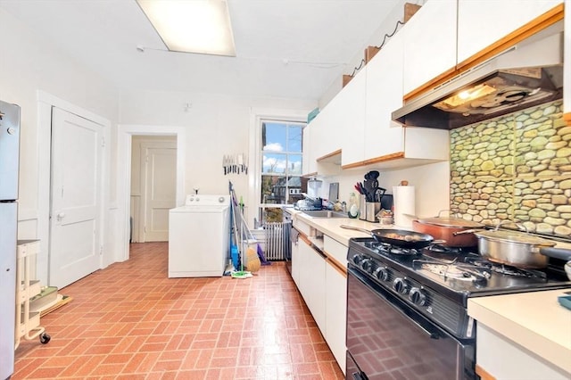 kitchen featuring washer / clothes dryer, gas stove, under cabinet range hood, white cabinetry, and decorative backsplash