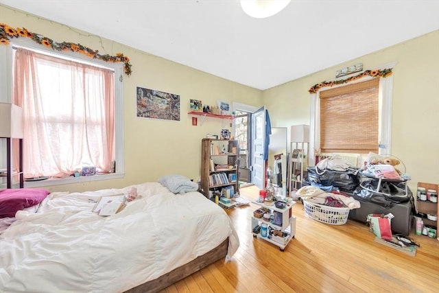 bedroom with multiple windows and wood-type flooring