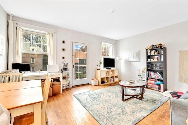 living area with light wood finished floors, an office area, and baseboards
