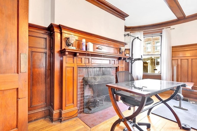 office featuring crown molding, light wood-style flooring, and a brick fireplace