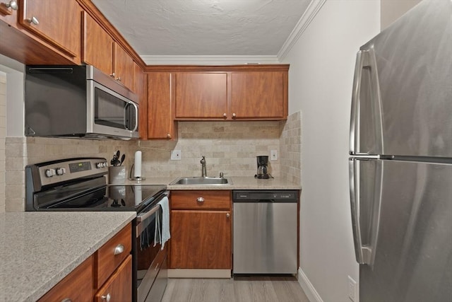 kitchen featuring backsplash, sink, light hardwood / wood-style flooring, ornamental molding, and stainless steel appliances