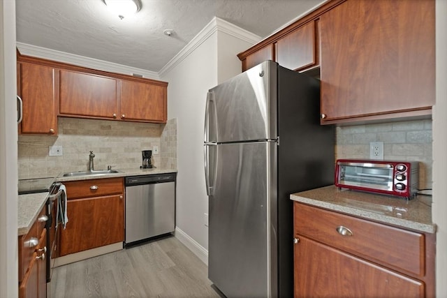 kitchen with sink, tasteful backsplash, crown molding, light hardwood / wood-style floors, and appliances with stainless steel finishes