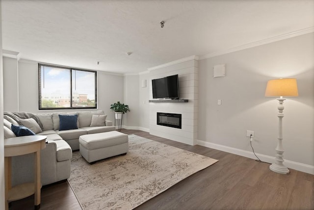 living room with a large fireplace, crown molding, and dark wood-type flooring