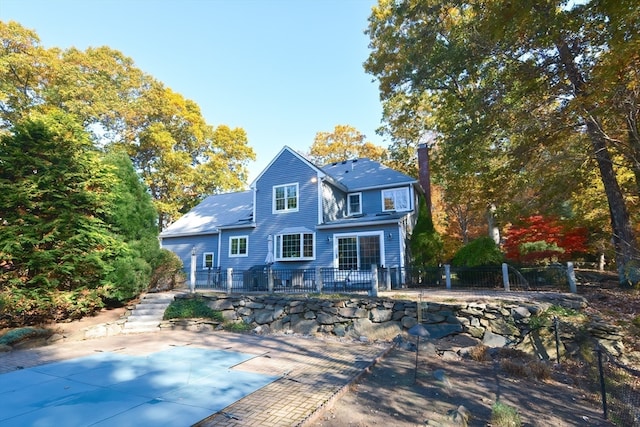 back of property featuring a pool side deck and a patio area