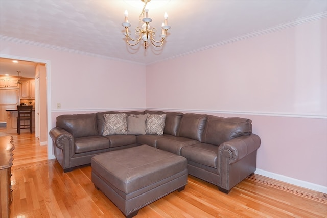 living room featuring a notable chandelier, light wood-type flooring, and ornamental molding