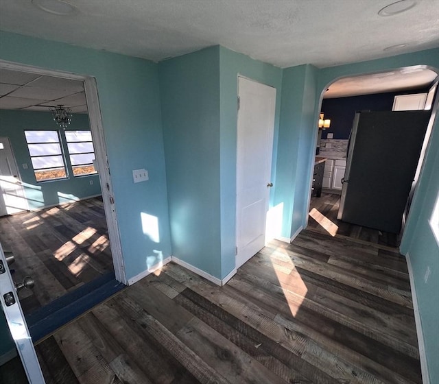 empty room featuring dark hardwood / wood-style floors and an inviting chandelier