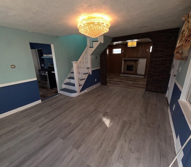 unfurnished living room featuring a fireplace, hardwood / wood-style floors, and a textured ceiling