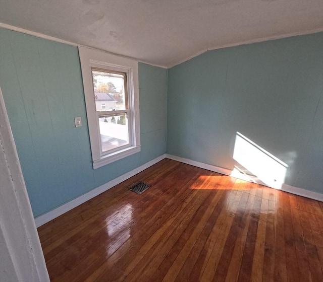 spare room featuring dark hardwood / wood-style floors and lofted ceiling